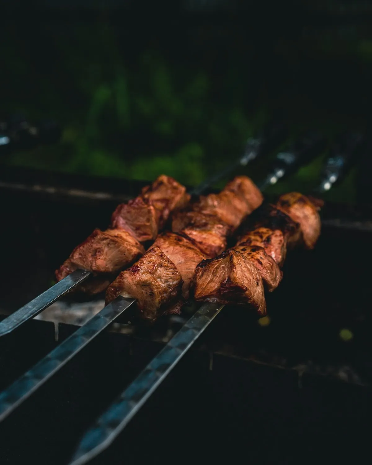 Kebabs on skewers over a charcoal grill