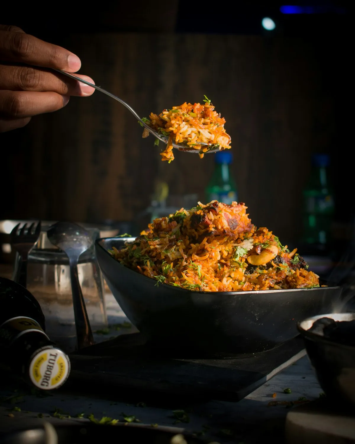 A spoonful of saffron rice lifted from a dark pan