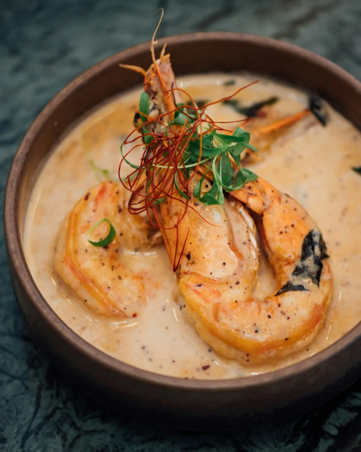 Tiger prawns in a creamy coconut curry, topped with chilli threads